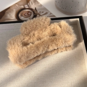 Gros plan sur une grande pince à cheveux carrée en peluche de couleur kaki clair