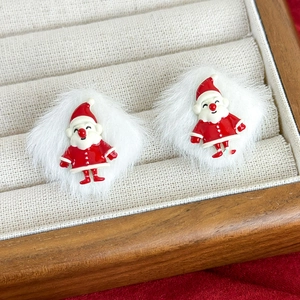 Close-up of Santa Claus stud earrings with white faux fur balls and red enamel details