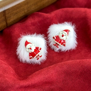 Detailed close-up of festive white plush ball earrings with Santa Claus charms