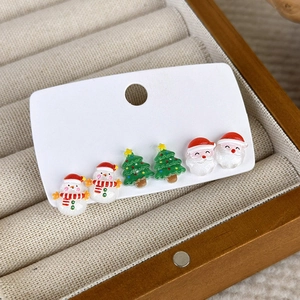 Gros plan sur un ensemble de boucles d'oreilles de Noël avec bonhomme de neige et sapin