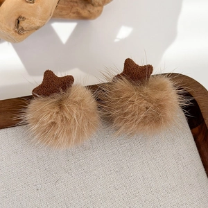 Dettaglio di orecchini a stella in peluche con maglia marrone e dettagli in ecopelliccia beige