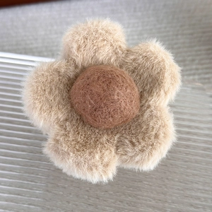 Vue détaillée de la pince à cheveux fleur en peluche aux tons terreux marron doux