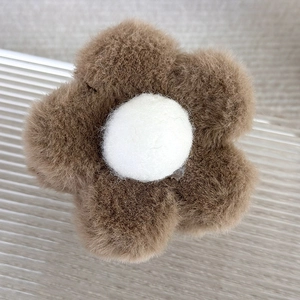 Vue détaillée de la pince à cheveux fleur en peluche marron avec une texture douce et centre blanc