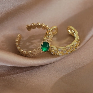Dettaglio ravvicinato dell'anello con smeraldo e fascia dorata su seta elegante
