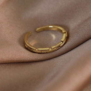 Dettaglio dell'anello vintage in oro 18K testurizzato su sfondo di seta marrone