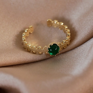 Macro di anello vintage dorato con grande pietra incastonata color verde smeraldo