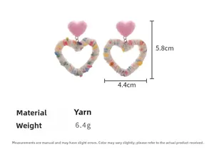 Macro view of dimensions for rainbow knitted heart earrings with plush pink details