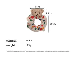 Vue détaillée du chouchou ours en peluche avec dimensions 10cm et motifs de cœurs colorés