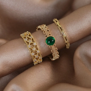 Set di anelli d'oro vintage con smeraldo e zirconi a stella su seta lussuosa