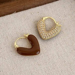 Dettaglio orecchini vintage dorati con smalto marrone e zirconi a pavé lucidi