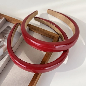 Détail du serre-tête en cuir verni rouge avec tissu antidérapant et design épais rétro