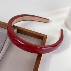 Détail d'un serre-tête en cuir verni rouge foncé avec doublure en velours antidérapant