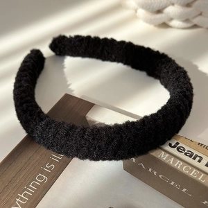 Gros plan détaillé d'un bandeau en peluche noir doux sur un support en bois