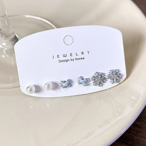 Set of 6 winter stud earrings featuring light blue snowflakes, bows, and white pearls