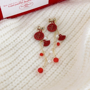 Vue détaillée de boucles d'oreilles rouge Nouvel An avec signe Fu et longs pompons