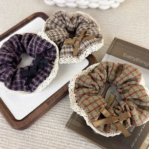 Trois chouchous pied-de-poule avec bordure en dentelle et nœuds sur fond en tricot