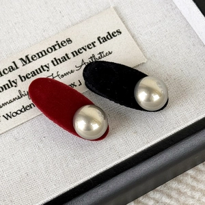 Detailed macro view of vintage red and black flocked hair clips with metallic silver beads