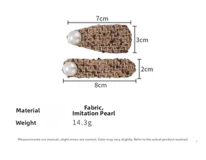 Close-up of brown tweed hair clips with pearl detail showing dimensions and fabric texture