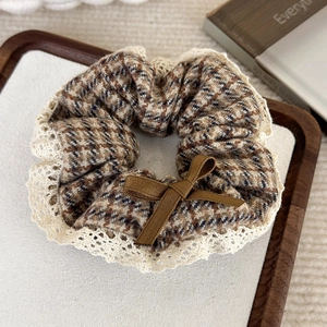 Détail du chouchou motif pied-de-poule avec bordure en dentelle et nœud en ruban brun
