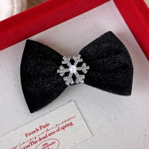 Détail d'une barrette noeud en velours noir avec flocon de neige strass et perle