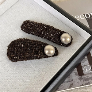 Detail of tweed fabric hair clips with pearls in brown and silver metallic threads