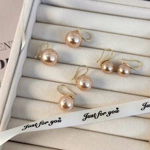 Pendientes de perlas champán con ganchos dorados en una caja de regalo de terciopelo