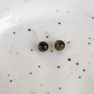 Close-up of vintage tiger eye stone stud earrings with golden texture and chatoyancy