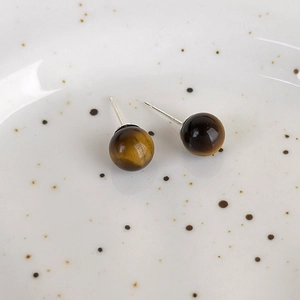 Detailed close-up of vintage tiger eye stud earrings with natural brown stone texture