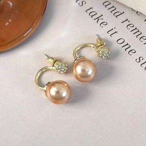 Detail of champagne gold pearl earrings with sparkling rhinestones and C-shape hooks