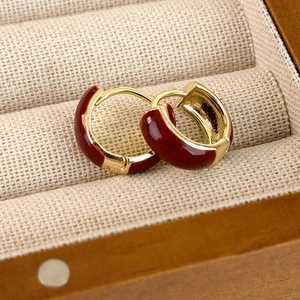 Elegant red enamel hoop earrings with gold-plated metal finish in a luxury jewelry box