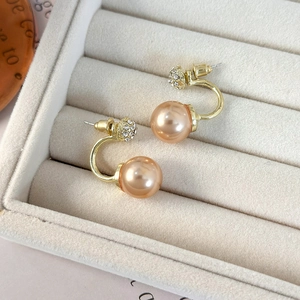 Champagne gold pearl earrings with rhinestone ball studs on a soft velvet jewelry display
