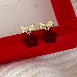 Winter red velvet flower earrings with golden bow design on red jewelry box