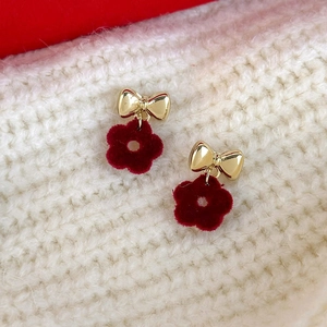 Winter sweet gold bow and red flocked flower drop earrings on knit background