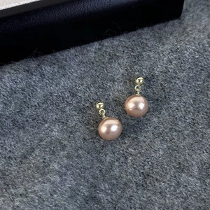 Vintage champagne pearl stud earrings with gold metal beads on grey knit fabric