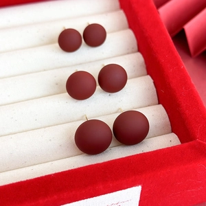Trois paires de boucles d'oreilles rondes rouge foncé mat de tailles variées en écrin