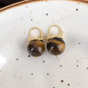 Detail of vintage French gold leverback earrings featuring sphere tiger eye stone beads