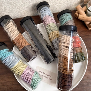 Elastic braided hair ties set in clear jars featuring vibrant Morandi color palettes