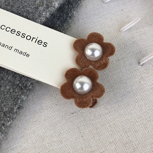 Detail view of brown velvet flower hair clips with elegant pearls for autumn and winter styles