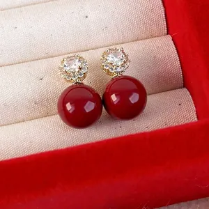 Orecchini pendenti con perle rosse e cristalli di zircone in una scatola regalo di lusso