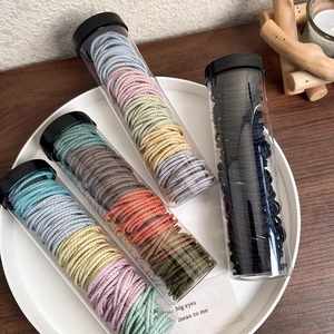 Macro view of spiral hair ties in transparent storage tubes on a white round tray