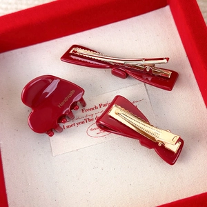 Conjunto de tres accesorios rojos para el cabello con pinza y horquillas de lazo