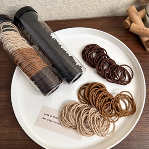 Elastic spiral hair ties set in earthy tones for high ponytail styling in a clear jar