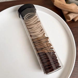 Jar of high elasticity earth-tone hair ties in beige and brown colors with storage