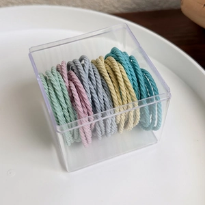 Detailed view of colorful high-elasticity hair bands organized in a clear acrylic storage box