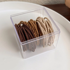 Neutral earth tone braided hair ties set in a clear square plastic storage box