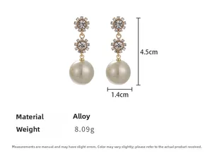 Detailed view of sunflower rhinestone earrings with faux gold pearls and size measurements