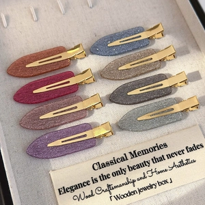 Detail view of 8-piece glitter duckbill hair clips set in a cream jewelry box organizer