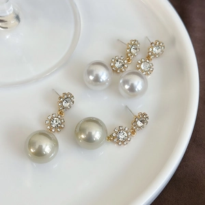 Detailed macro view of vintage long pearl drop earrings with elegant golden floral accents