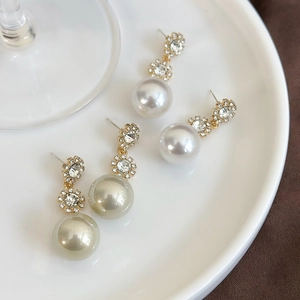 Elegant vintage long drop earrings with large round pearls and sparkling rhinestone clusters