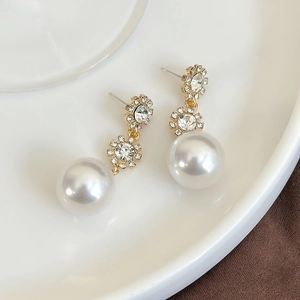 Detail of gold floral rhinestone cluster earrings with large white round pearls